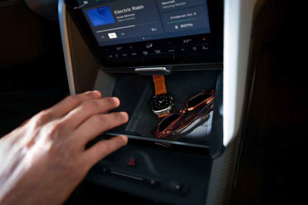 Una mano si protende verso il vano «My Private Locker» della Ford Capri®. Al suo interno si vedono un orologio e un paio di occhiali da sole.