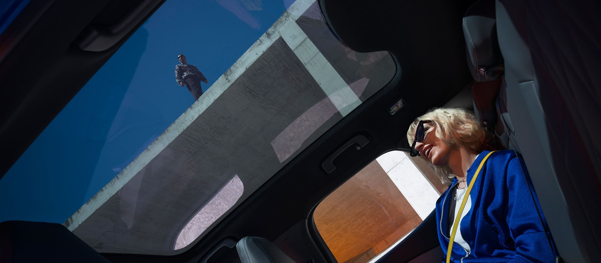 Una persona è seduta su una nuova Ford Capri® e si gode il tetto panoramico.