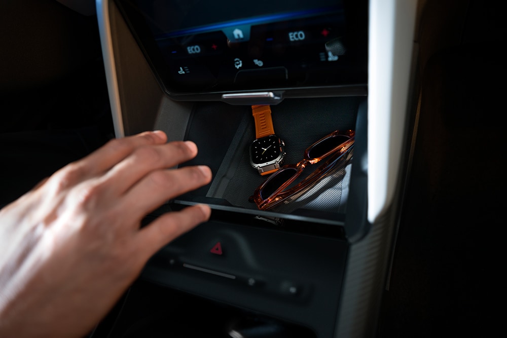 Una mano si protende verso il vano «My Private Locker» della Ford Capri®. Al suo interno si vedono un orologio e un paio di occhiali da sole.