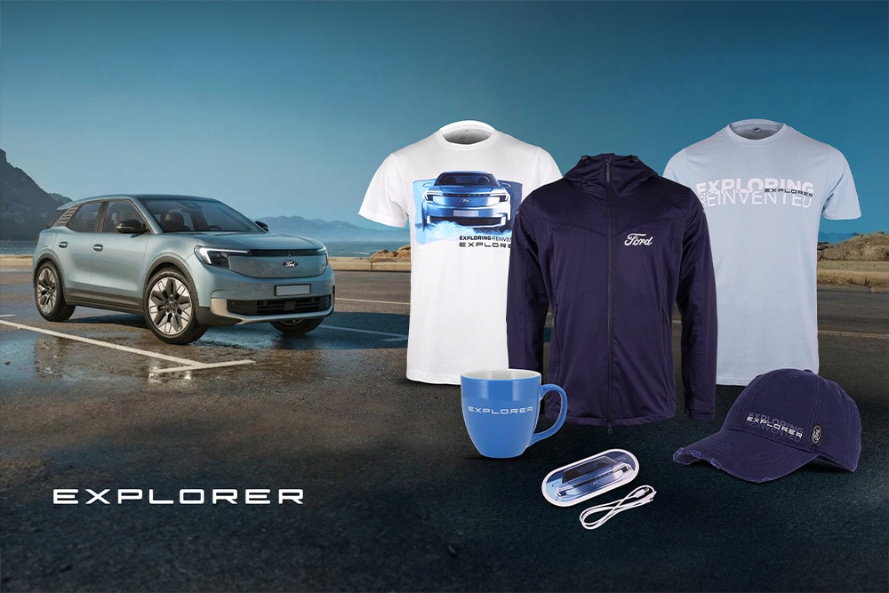 Blue Ford Explorer merchandise including jackets, cap, and other accessories, displayed in front of a blue Ford Explorer.