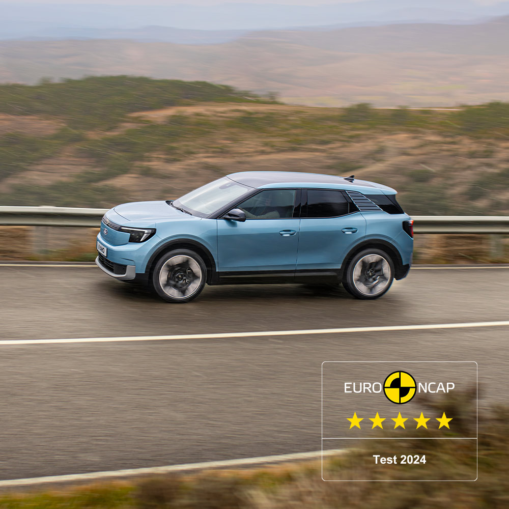 Un Ford Explorer blu in marcia su una strada di montagna, con il logo delle cinque stelle Euro NCAP 2024 in alto a sinistra.