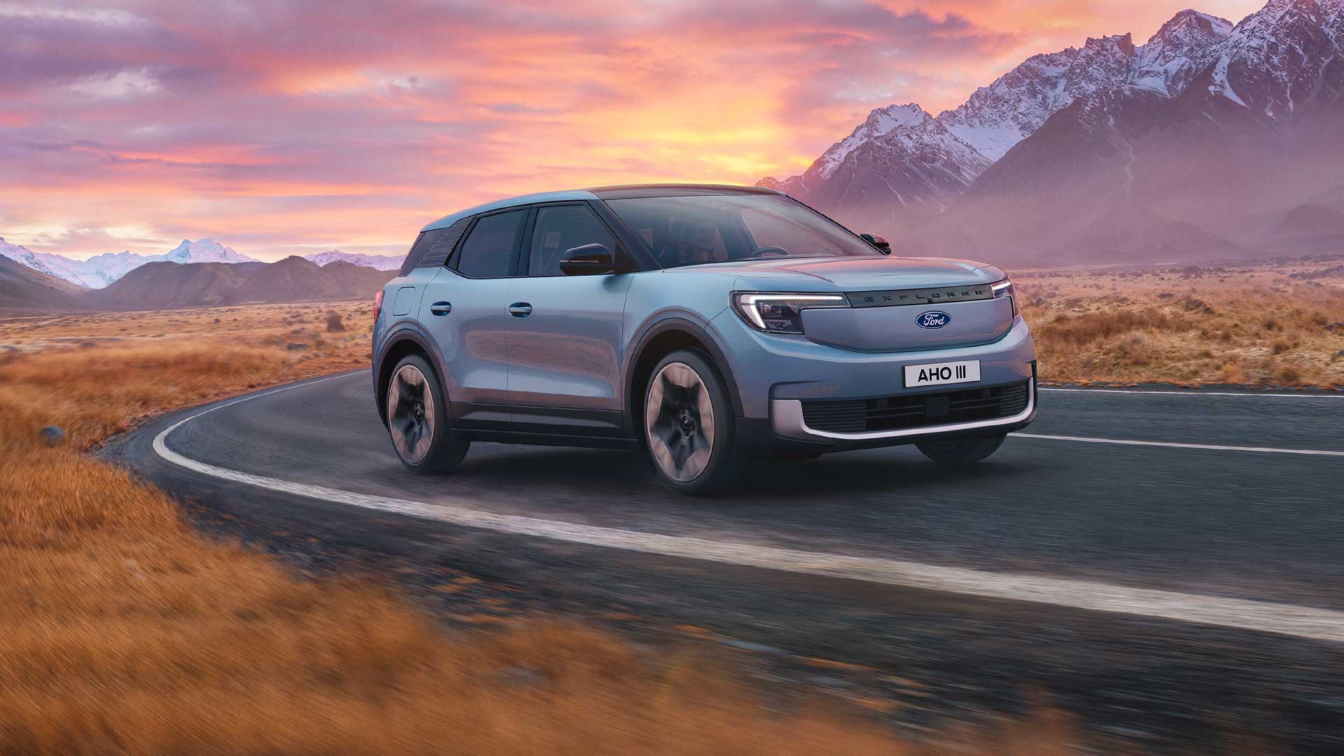 Il Ford Explorer completamente elettrico percorre una strada di montagna al tramonto.