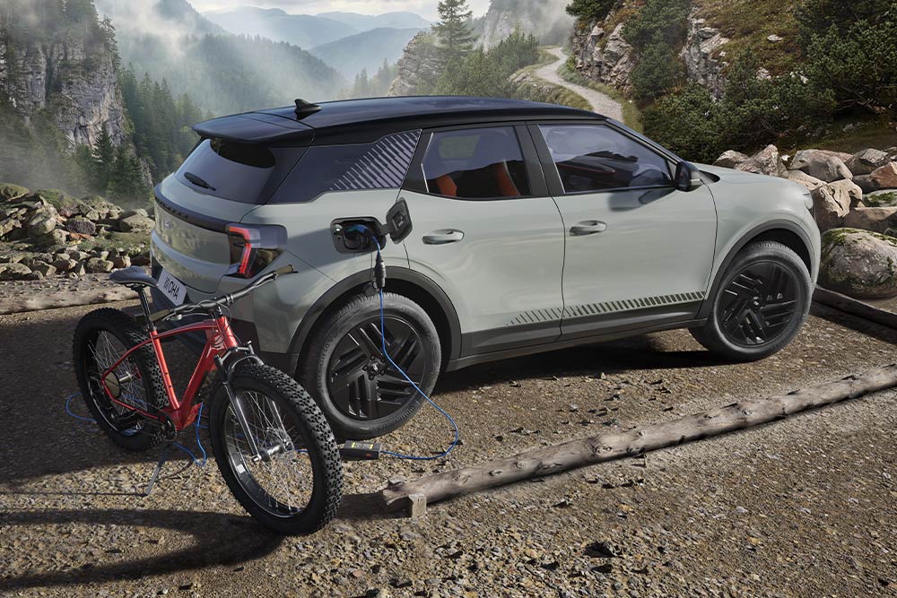 Una e-bike che si carica da una Ford Explorer®, paesaggio montuoso sullo sfondo.