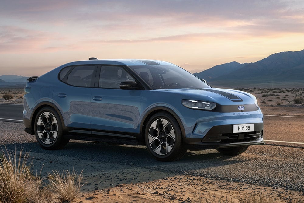 Ford Capri® Collection blu percorre una strada di montagna polverosa.