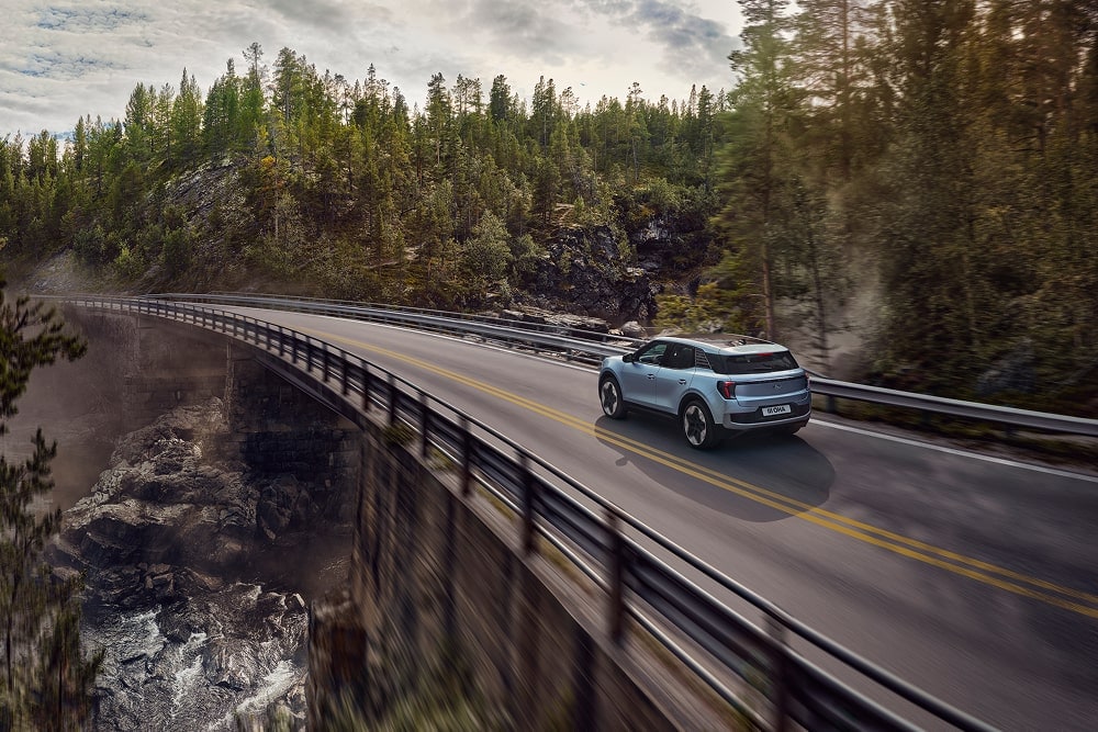 Un SUV familiare Ford Explorer blu in viaggio su una strada di montagna.