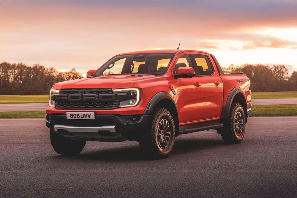 Un pick-up  Ford Ranger Raptor arancione parcheggiato in un paesaggio panoramico.