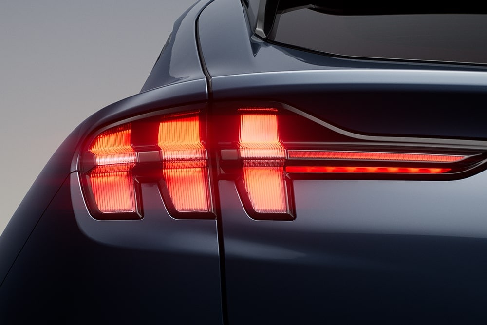 Primo piano su una luce posteriore tripla accesa di una Ford Mustang Mach-E sportiva.