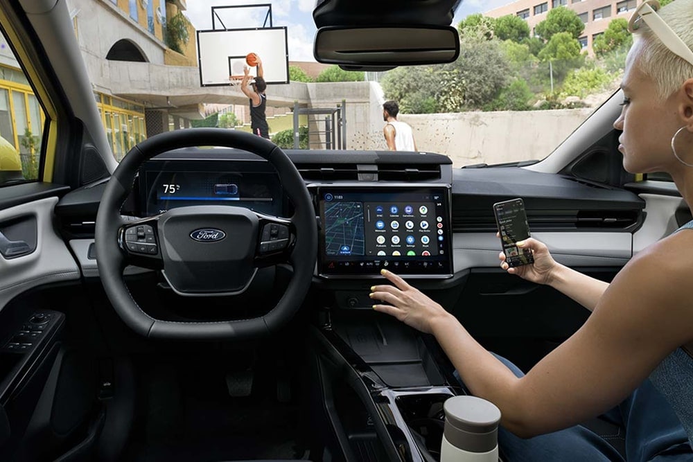 Interno di un’utilitaria Ford Puma Gen-E, con elementi di comando sul touchscreen.
