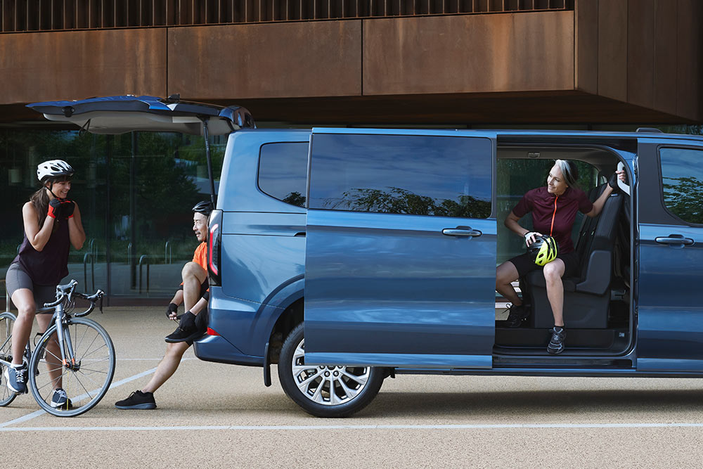 Vista laterale del nuovissimo Tourneo Custom con persone intorno