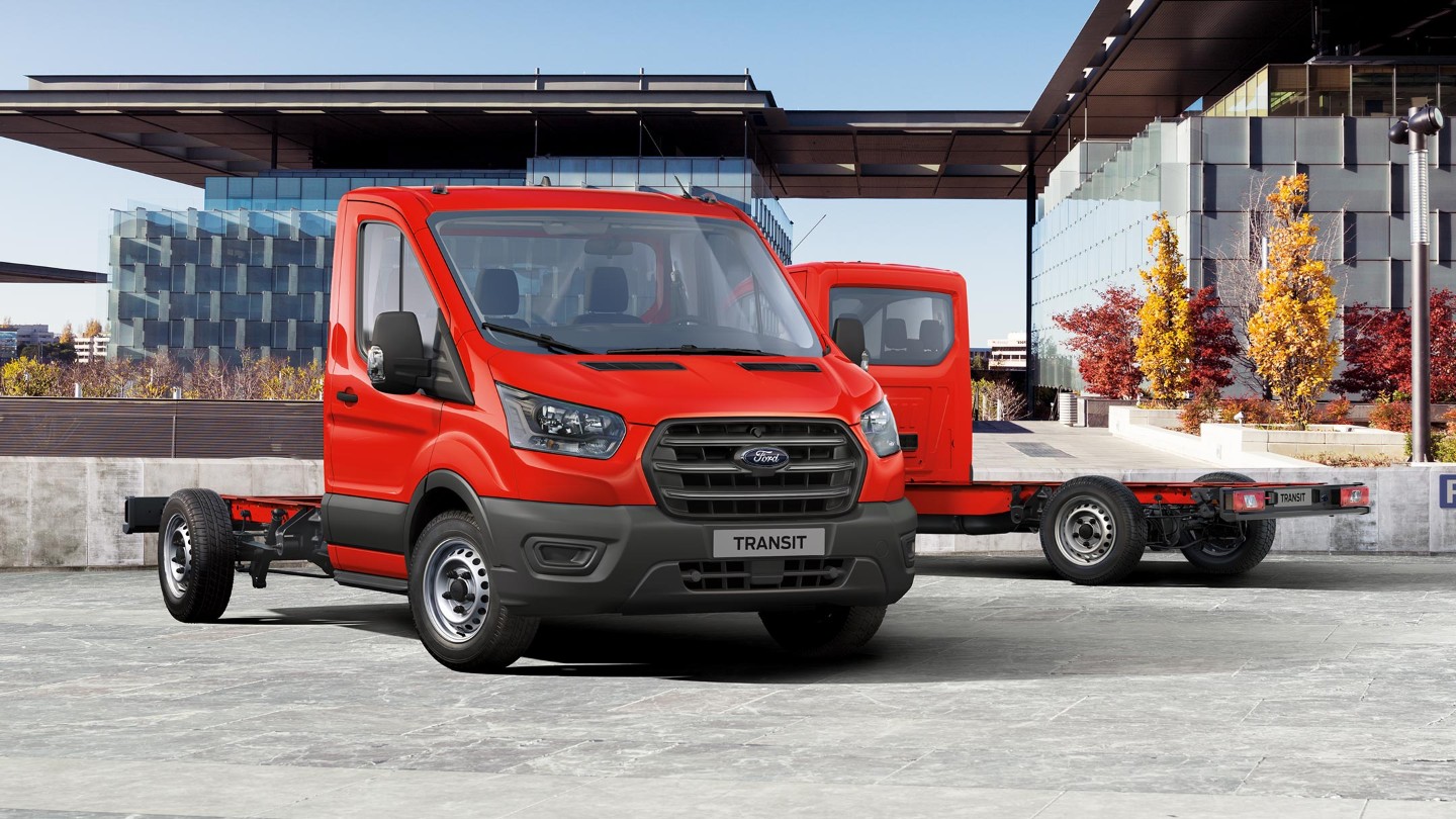 Ford Transit Chassis Cab rosso, vista frontale a tre quarti, parcheggiato davanti a un edificio