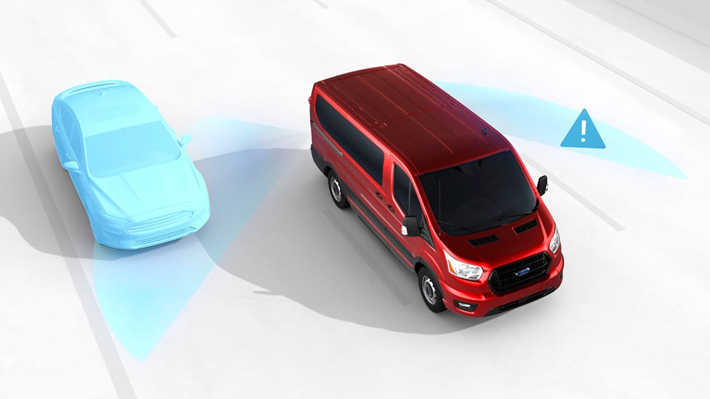 Ford E-Transit color argento, vista posteriore a tre quarti, parcheggiato davanti a un edificio moderno