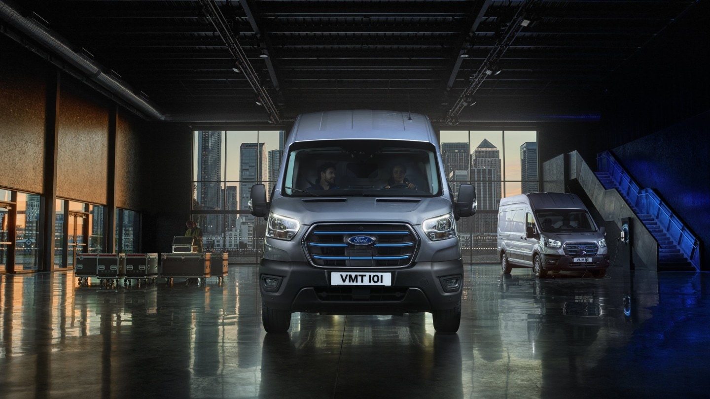 Ford E-Transit bianco, vista frontale, parcheggiato all’interno di un padiglione espositivo