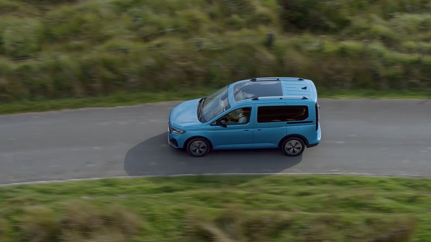 Ford Tourneo Connect azzurro, vista laterale dall’alto, in transito su una strada extraurbana