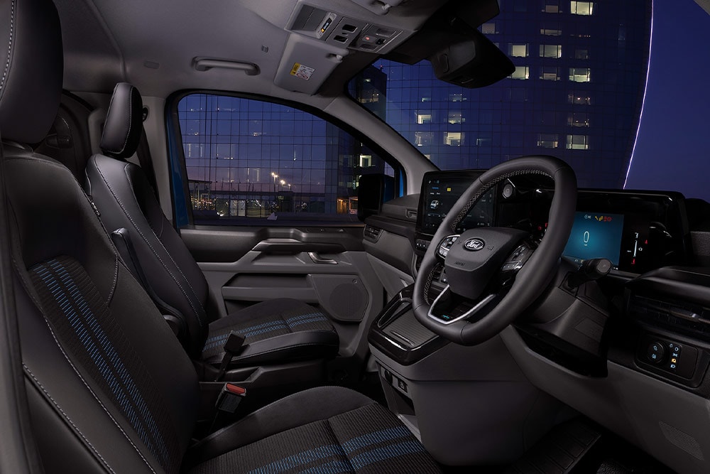 Vista interna del furgone elettrico Ford E-Transit Custom con sedili per il conducente e il passeggero.