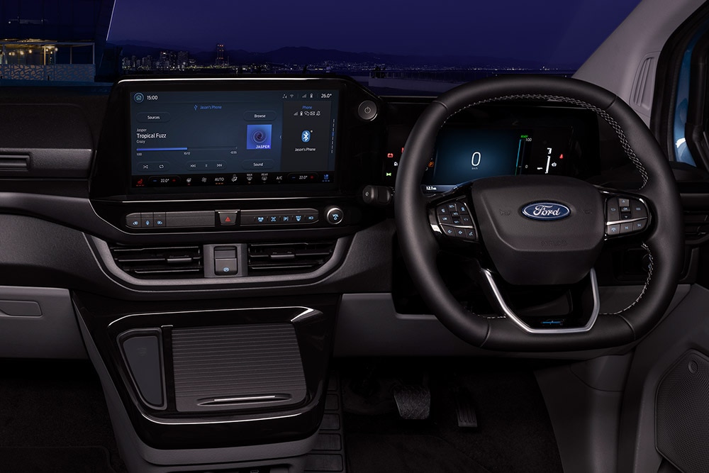 Vista interna del furgone elettrico Ford E-Transit Custom con i sedili del conducente e del passeggero.