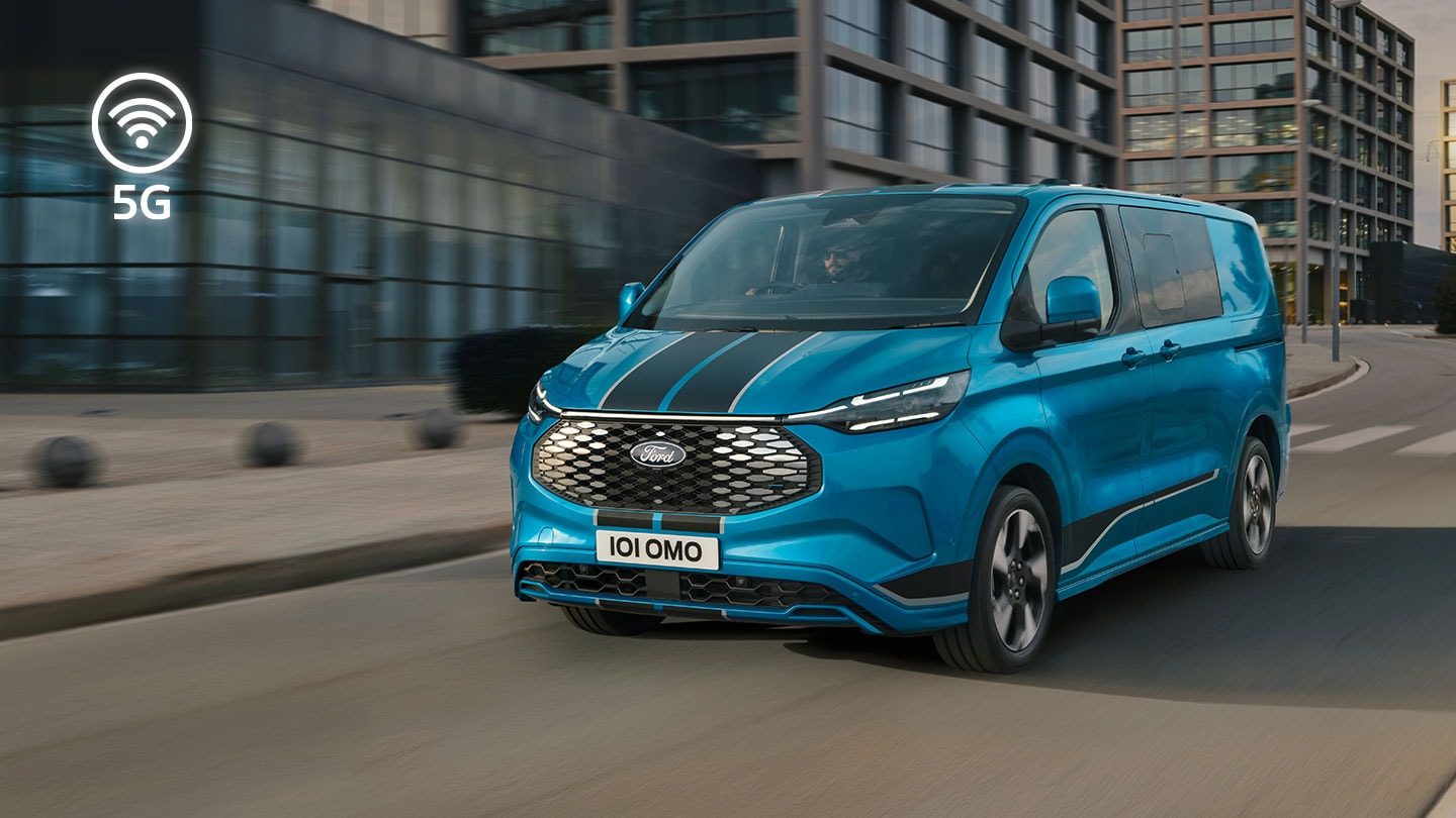 Un furgone elettrico Ford E-Transit Custom blu circola in città.