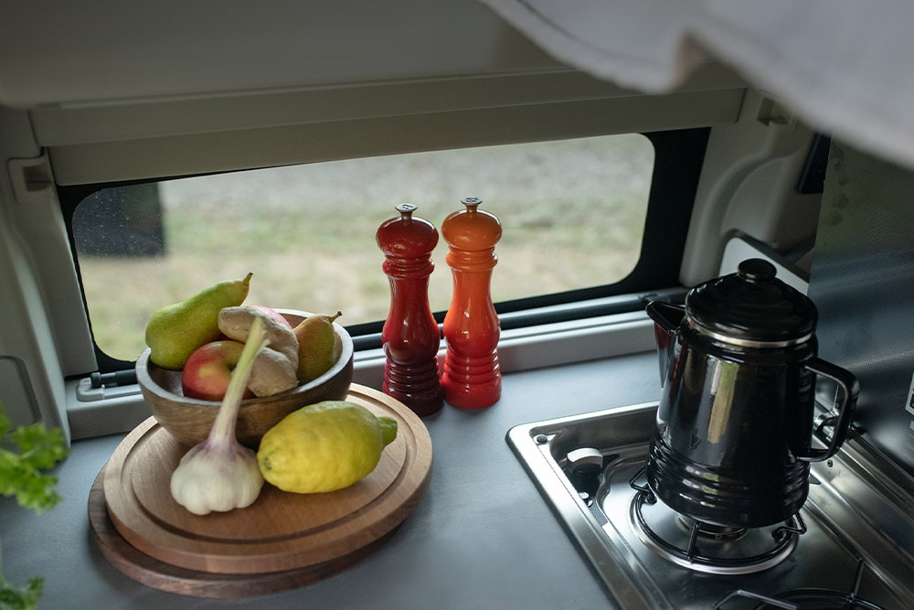 Ford Transit Custom Nugget: piano cottura integrato con bollitore e frutta sul piano.