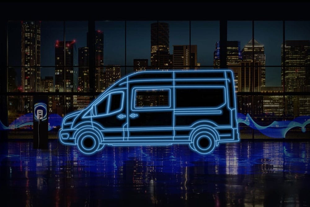 Sagoma blu fluo di una Ford E-Transit Double Cab-in-Van e stazione di ricarica sul profilo della città.