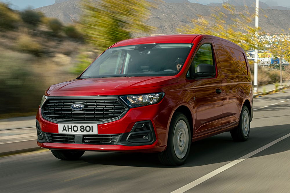 Ford Transit Connect che circola su strada, mostrando la griglia anteriore e i fari automatici.