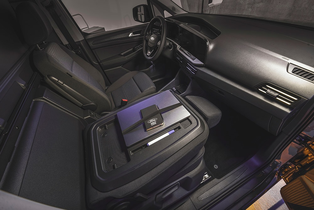 Interni di Ford Transit Connect  con cruscotto, sedili, laptop e telefono sulla console centrale.