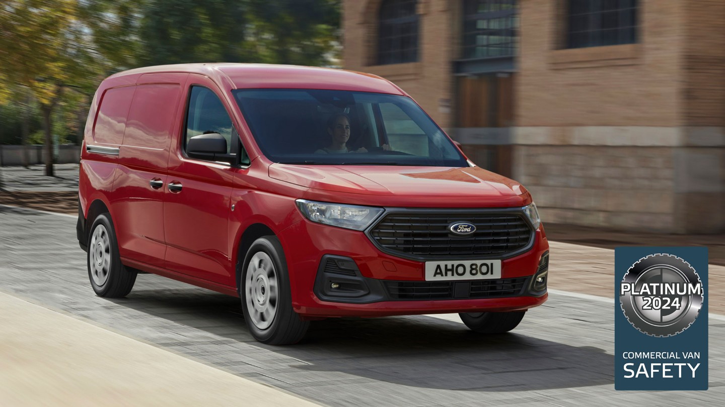 Ford Transit Connect Trend color Maple Red con calandra e fari automatici, in marcia lungo una strada.