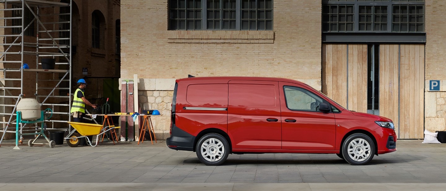 Un Ford Transit Connect® color Maple Red con portello di carico laterale in sosta in un cantiere.