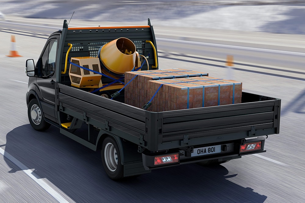 Ford Transit Chassis Cab in movimento con carico nel vano posteriore.