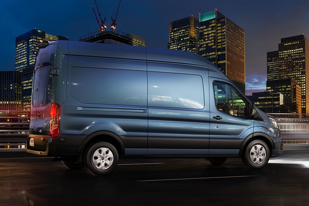 Furgone Ford Transit che attraversa la città di notte.