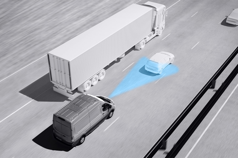 Disegno in scala di grigi di un Ford Transit Van con linee blu su strada raffiguranti l'uso di sistemi avanzati di assistenza alla guida.