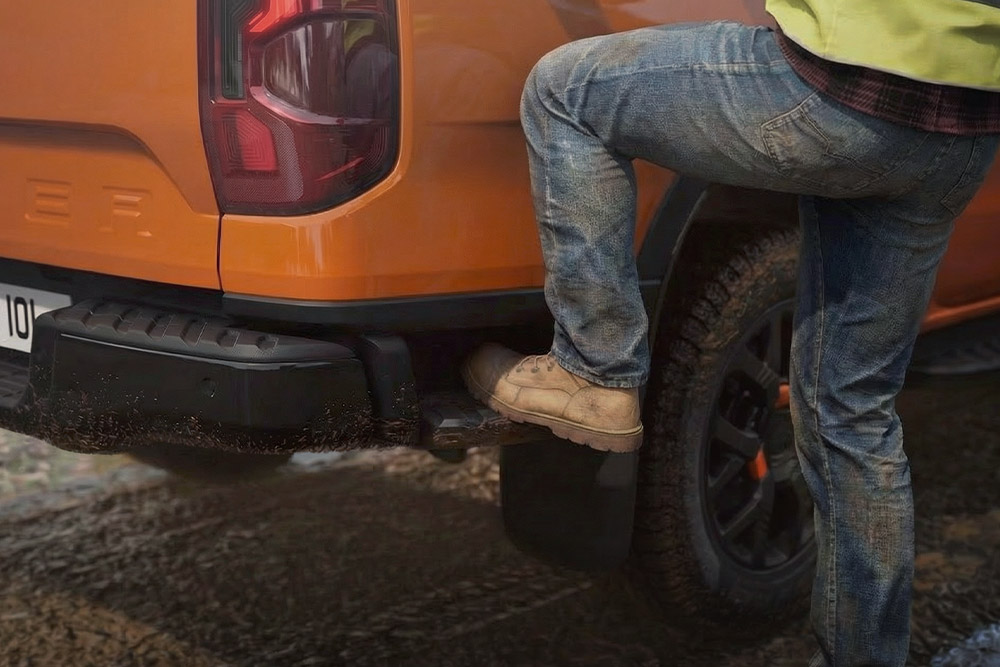 Lavoratore che sale sul gradino posteriore integrato del Ford Ranger Wildtrak.