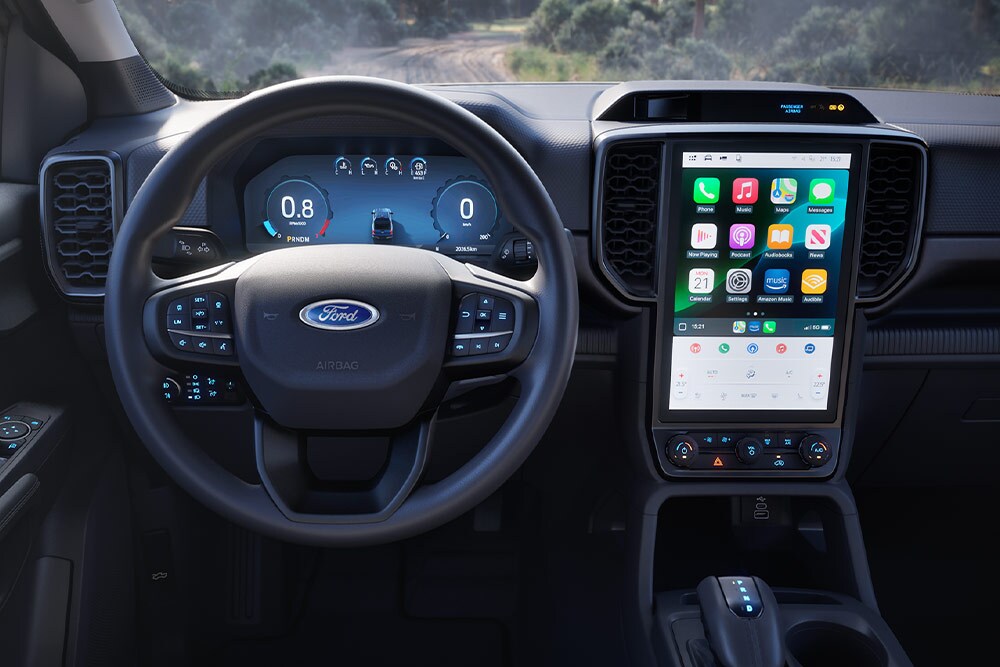 Vista interna di un Ford Ranger Super Cab, con particolare attenzione al volante, al cruscotto e allo schermo di infotainment.