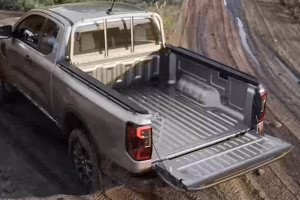 Un Ford Ranger XLT Super Cab argentato, parcheggiato su una superficie fangosa con portellone aperto, vista dall’alto.