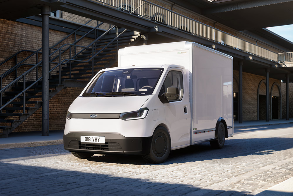 Furgone bianco Ford Transit City® Chassis Cab parcheggiato di fronte a un edificio in mattoni.