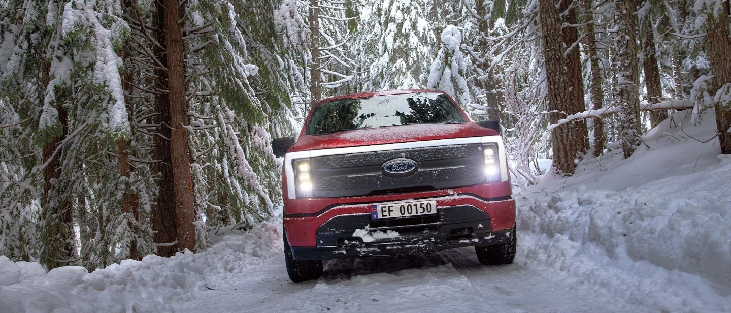 Ford F-150 Lightning driving through a snowy forest