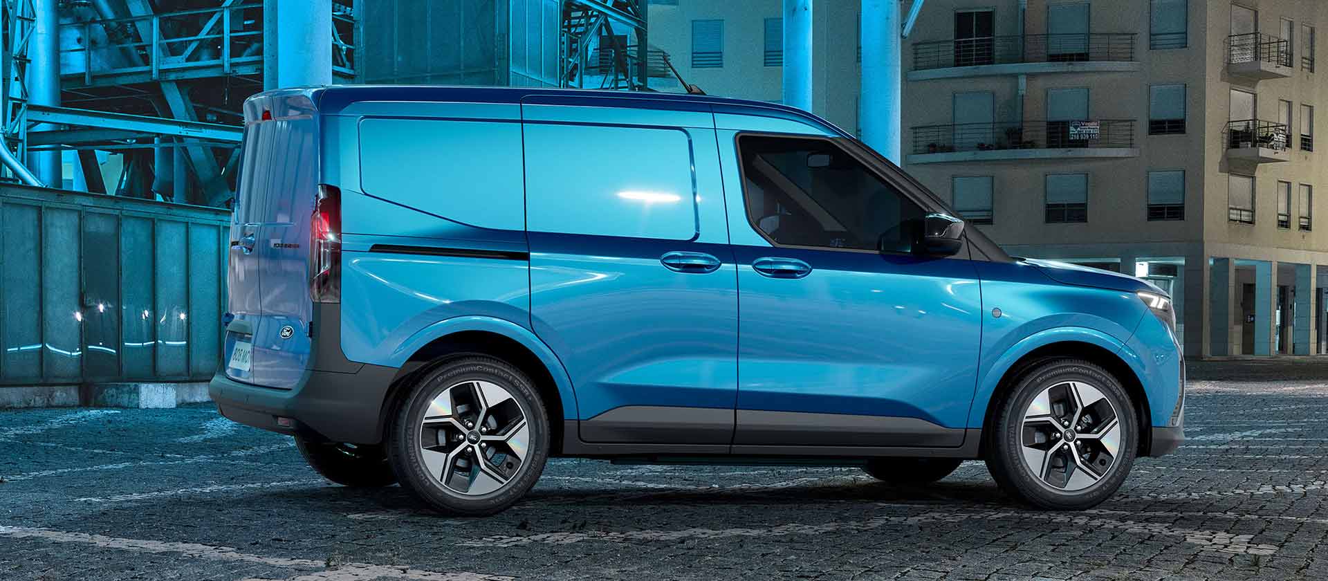 Ford E-Transit Courier grigio – Vista laterale, una donna carica l’auto