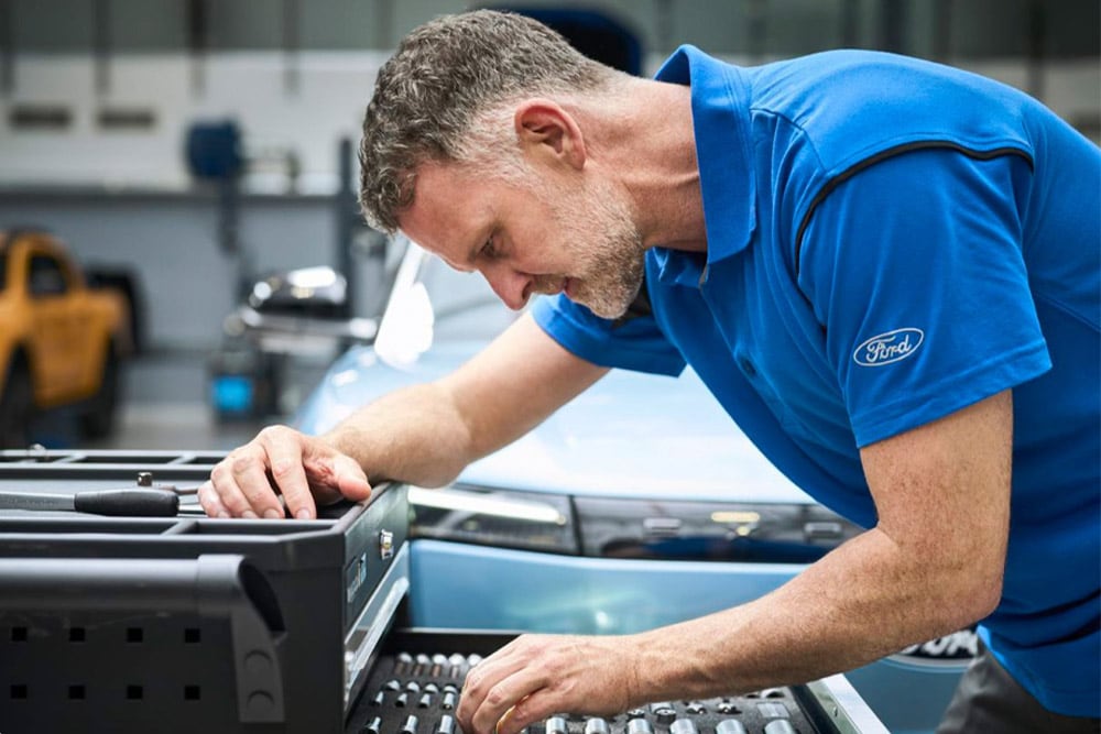 Primo piano di un tecnico autorizzato Ford al lavoro in un'autofficina.