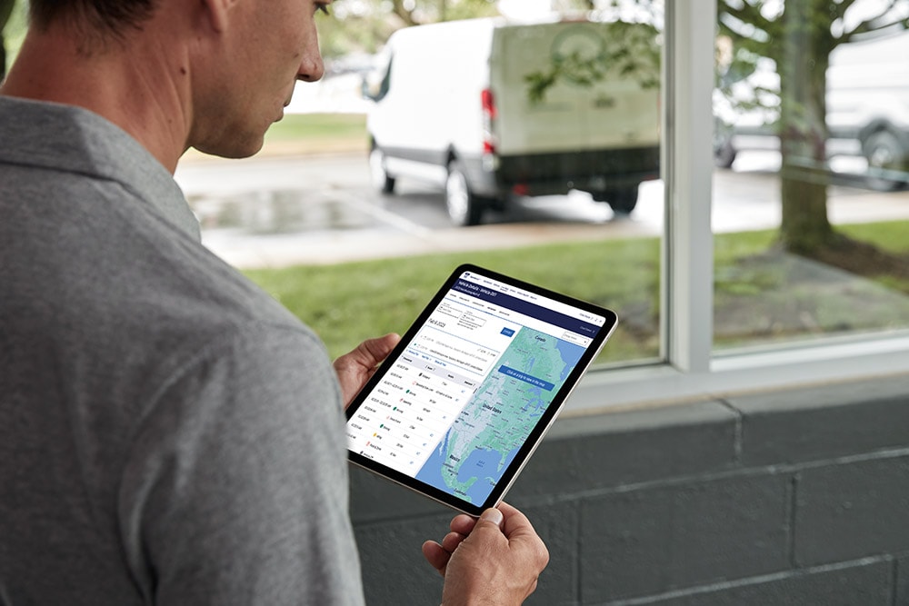 Uomo che guarda i dati del suo veicolo Ford su un tablet, monitorandoli in tempo reale.