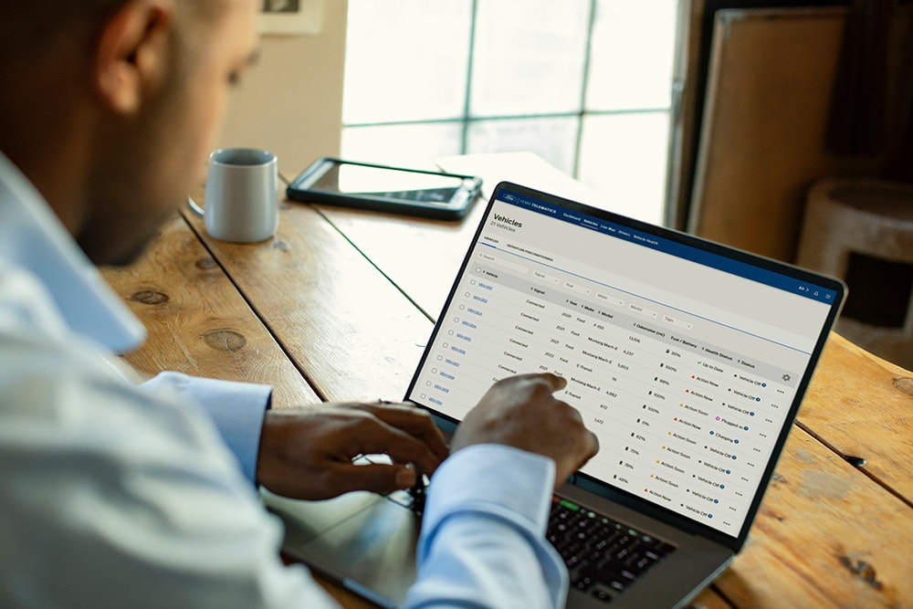 Un gestore di flotte Ford Pro che visualizza i dati del veicolo sul suo laptop.