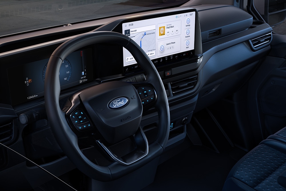 Vista interna di un veicolo Ford con un ampio cruscotto digitale, che mostra un cantiere attraverso il parabrezza.