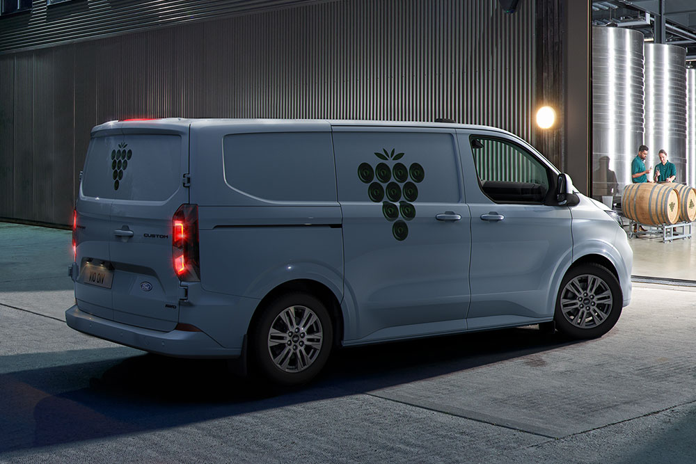 Un furgone Ford bianco parcheggiato fuori da un portone di magazzino di notte.