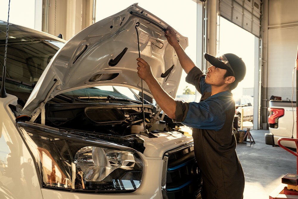 Un meccanico Ford che esegue la manutenzione su un furgone Ford Transit.