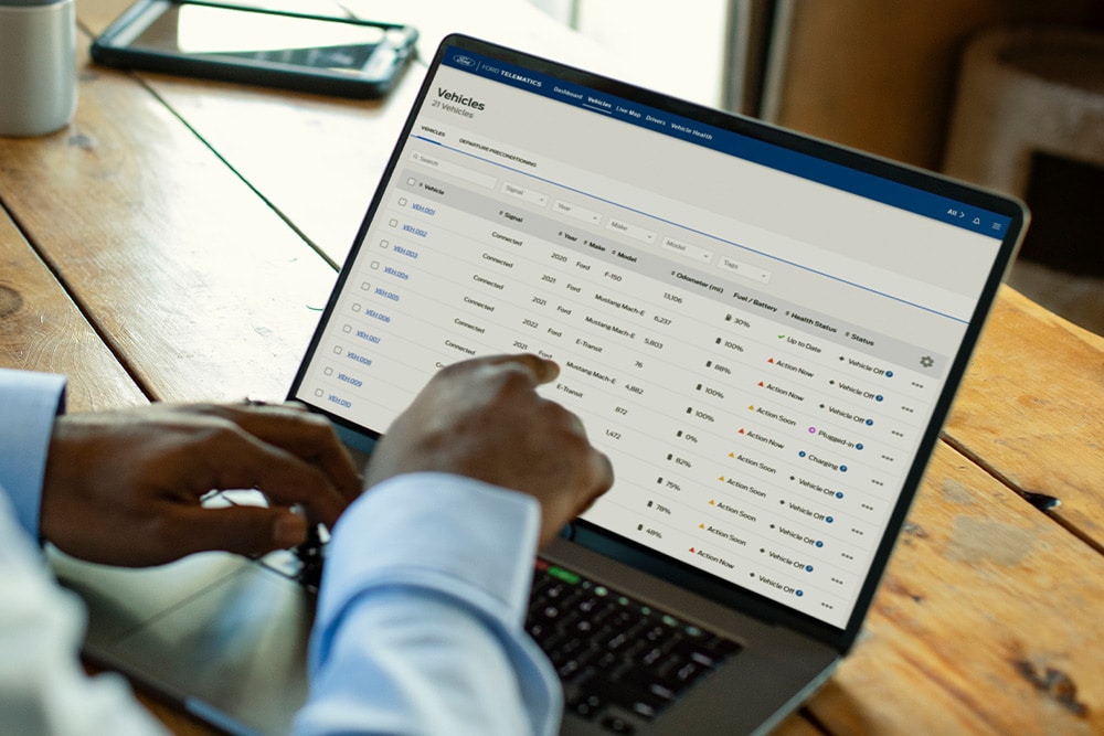 Un gestore di flotte Ford Pro che visualizza i dati del veicolo sul suo laptop.