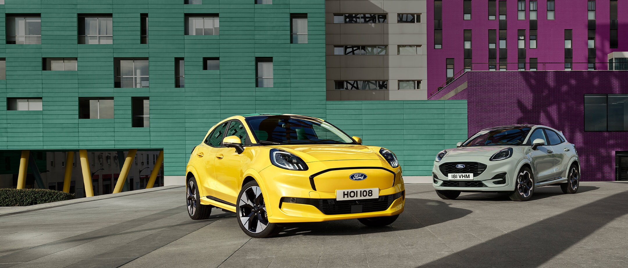 A yellow electric Ford Puma Gen-E® parked next to a grey petrol EcoBoost® Ford Puma®.