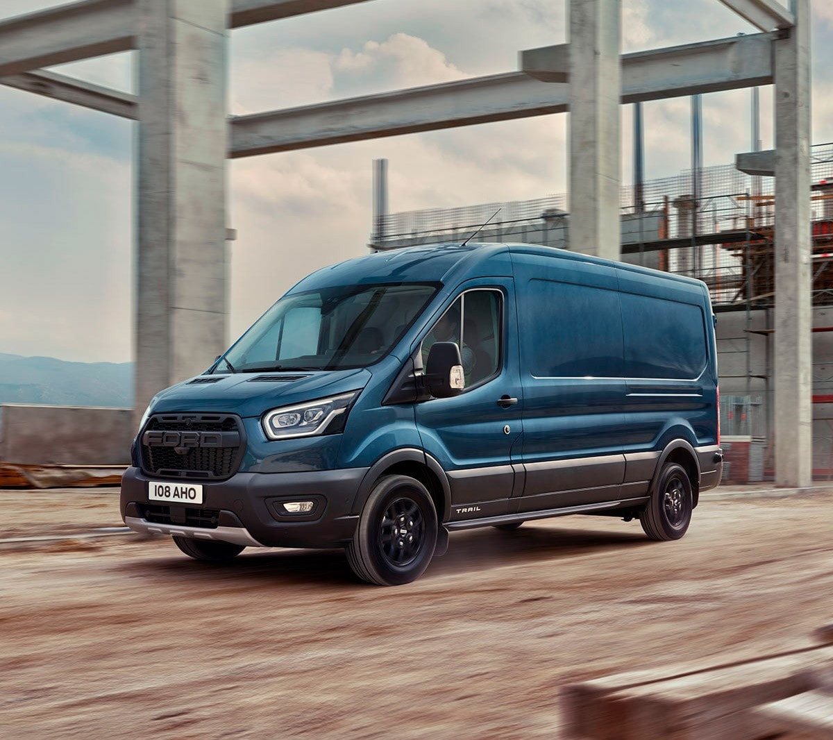 Ford Transit in blu nella vista laterale che guida sopra un cantiere