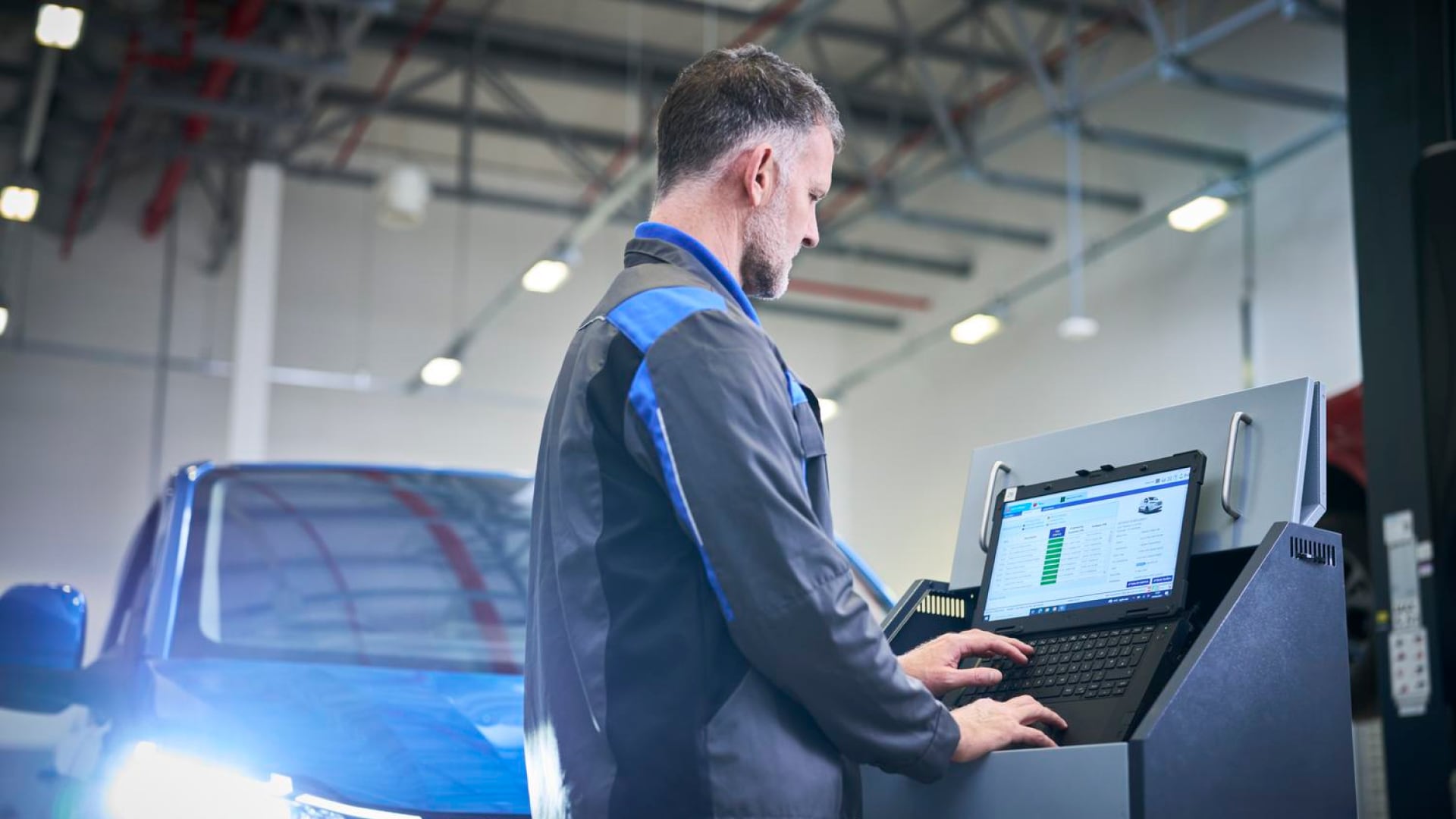 Vehicle technician using diagnostic laptop